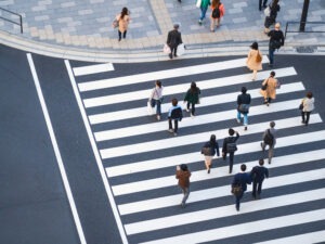 Overhead view of several pedestrians using a crosswalk in one of the four most dangerous California cities for pedestrians.