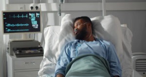 A man lies in the hospital and considers hiring a Palmdale catastrophic injury lawyer.
