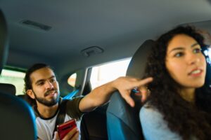 A man giving directions to his Uber driver. You can hire a Bakersfield Uber accident lawyer after a crash.