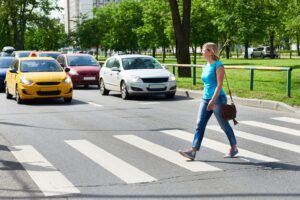 A woman crossing the street is about to be hit by a car. A pedestrian accident lawyer in Long Beach helps injured victims hold negligent drivers accountable.