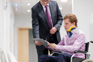A man in a wheelchair talks to a catastrophic injury lawyer in San Jose.
