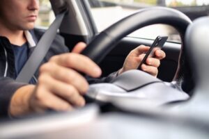 An Uber driver on the phone. You can hire a Santa Ana Lyft accident lawyer after a collision.