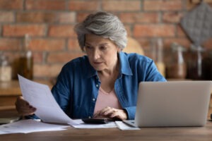Worried widow reading bills. Learn how wrongful death damages are calculated.