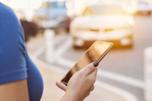 Person requesting a ride share on the phone. What happens if you get into an accident in a Lyft?