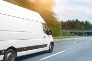 White delivery van moving fast to symbolize the damages you can recover in a delivery truck accident.