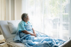 Older woman sits in a nursing home. A lawyer can tell you the categories of dependent adult abuse.