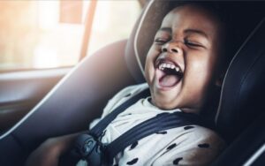 A toddler laughing in theri car seat. What is the best car seat for toddlers?